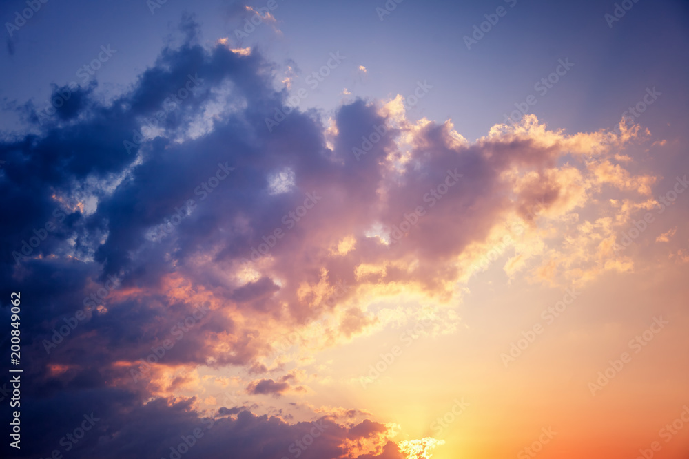 Bright colorful sunset sky, clouds and sun rays, natural background and texture