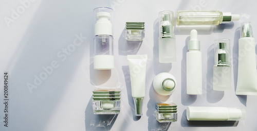 cosmetic packaging set on purple background. group of skincare cream serum oil . facial beauty cosmetic spa product. natural cosmetology concept skin treatment with green leaf and laboratory science 