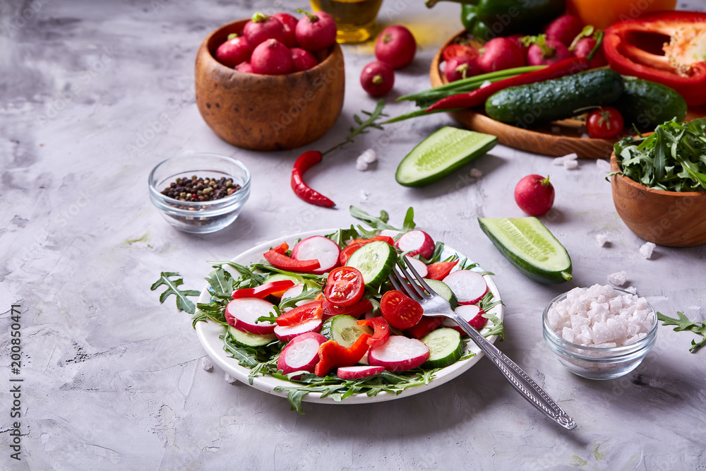 Still life of wooden plate with vegetables on white textured background, close-up, selective focus Still life of wooden plate with vegetables on white textured background, close-up, selective focus