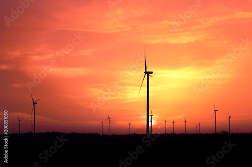 Windmill generators farm at sunset..