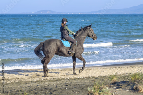 A woman is riding a horse on the coast 1