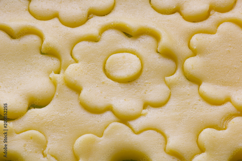 close up of pastry dough cut in flower shape for biscuits close up of pastry dough cut in flower shape for biscuits