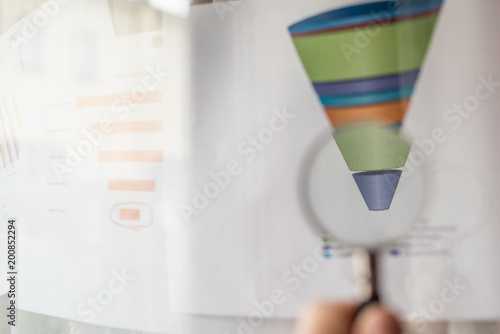 Colourful sales funnel chart under a magnifier lens for marketing data analysis photo