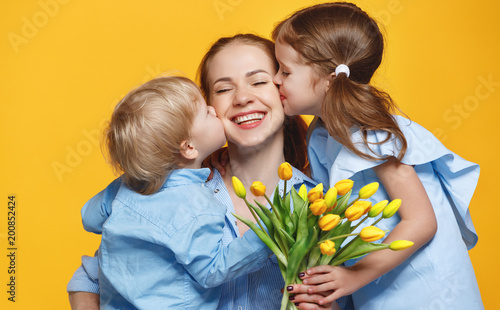 concept of mother's day. mom and children with flower on colored background