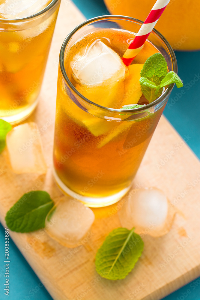 Glasses of iced tea with lemon slices and mint on turquoise wooden background Glasses of iced tea with lemon slices and mint on turquoise wooden background