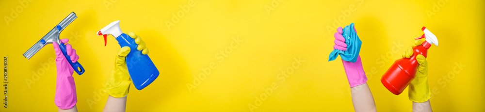 Fototapeta premium Cleaning concept - hands holding supplies on bright background