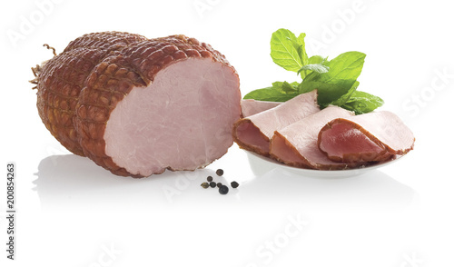 Piece of ham and slices on plate. Isolated on a white background