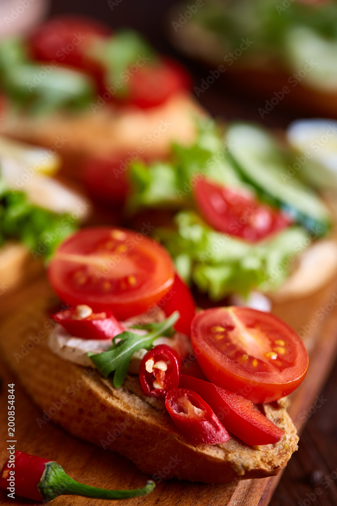 Breakfast sandwich with homemade paste, vegetables and fresh greens, shallow depth of field