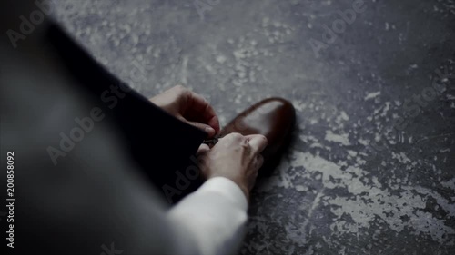 The man wears shoes. Tie the laces on the shoes. Men's style. Professions. To prepare for work, to the meeting.