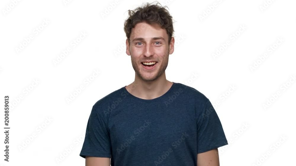 Portrait of smiling young man greeting with waving hand on camera, isolated over white background in studio closeup. Concept of emotions Portrait of smiling young man greeting with waving hand on camera, isolated over white background in studio closeup. Concept of emotions