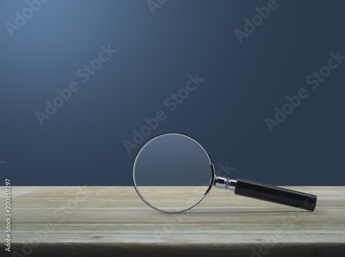 Magnifying glass on wooden table over light blue gradient background, Business analyzing concept