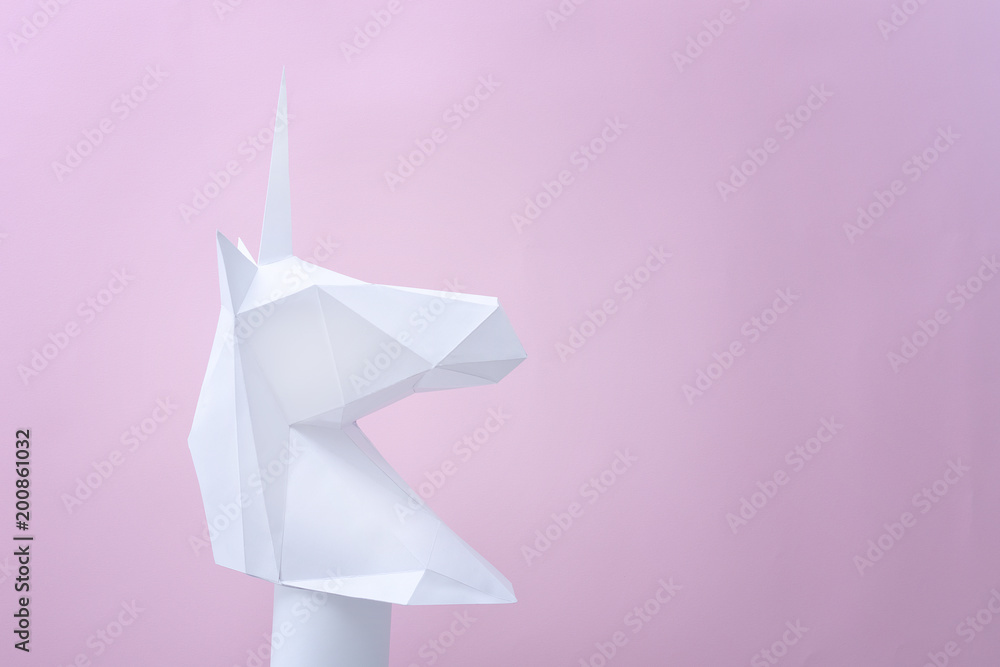 White paper unicorn on a pink background. Space for text White paper unicorn on a pink background. Space for text