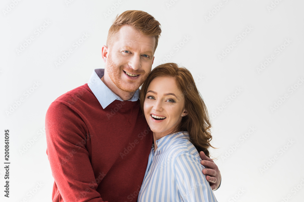 portrait of cheerful redhead couple standing together and smiling at camera isolated on grey portrait of cheerful redhead couple standing together and smiling at camera isolated on grey