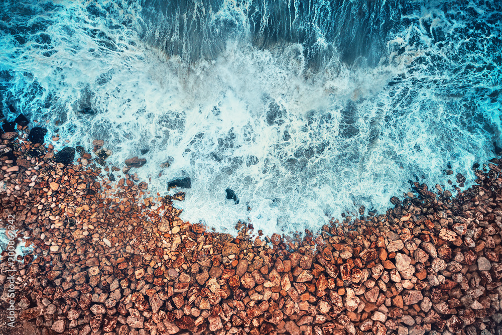 Aerial view of sea waves and rocky coast