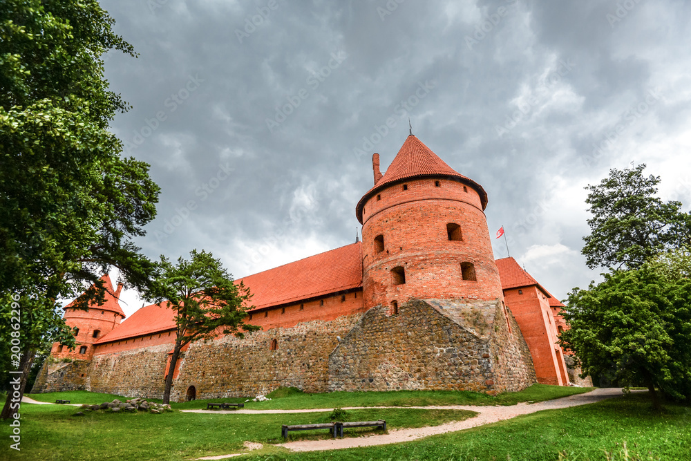 Trakai, Lithuania - August 15, 2017: Landscape of Trakai Island Castle, lake and wooden bridge, Lithuania. Trakai Island Castle and bright blue dramatic sky with clouds. 