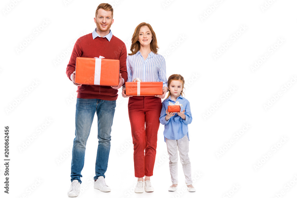 happy red haired family holding presents and smiling at camera isolated on white