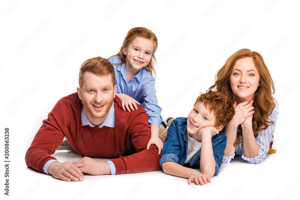 happy red haired family with two kids lying together and smiling at camera isolated on white happy red haired family with two kids lying together and smiling at camera isolated on white