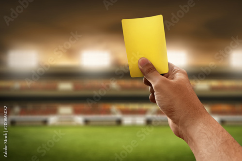 Soccer referee hand holding yellow card