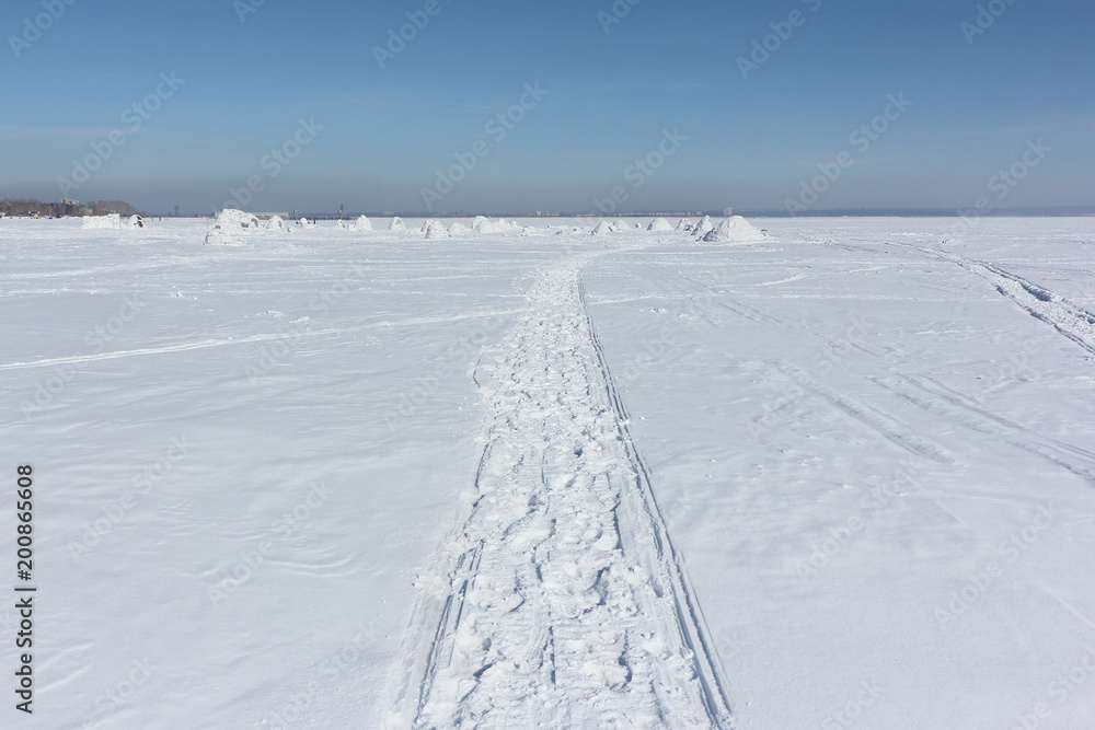 Trace of a snowmobile on a snowy surface of frozen reservoir, Siberia,  Ob Reservoir, Russia