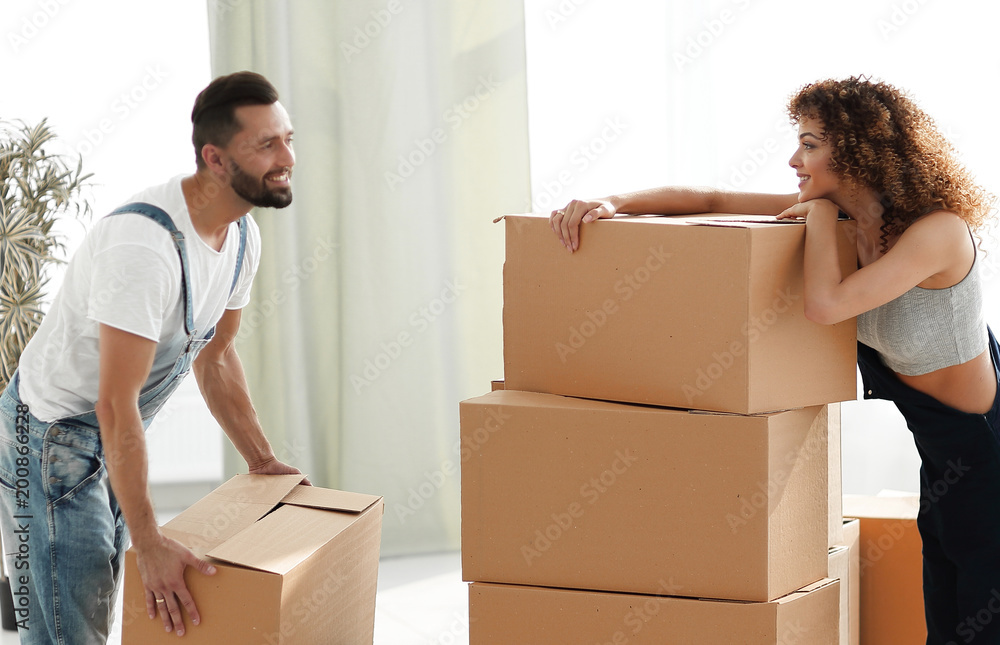 young couple unpacking boxes in a new house young couple unpacking boxes in a new house