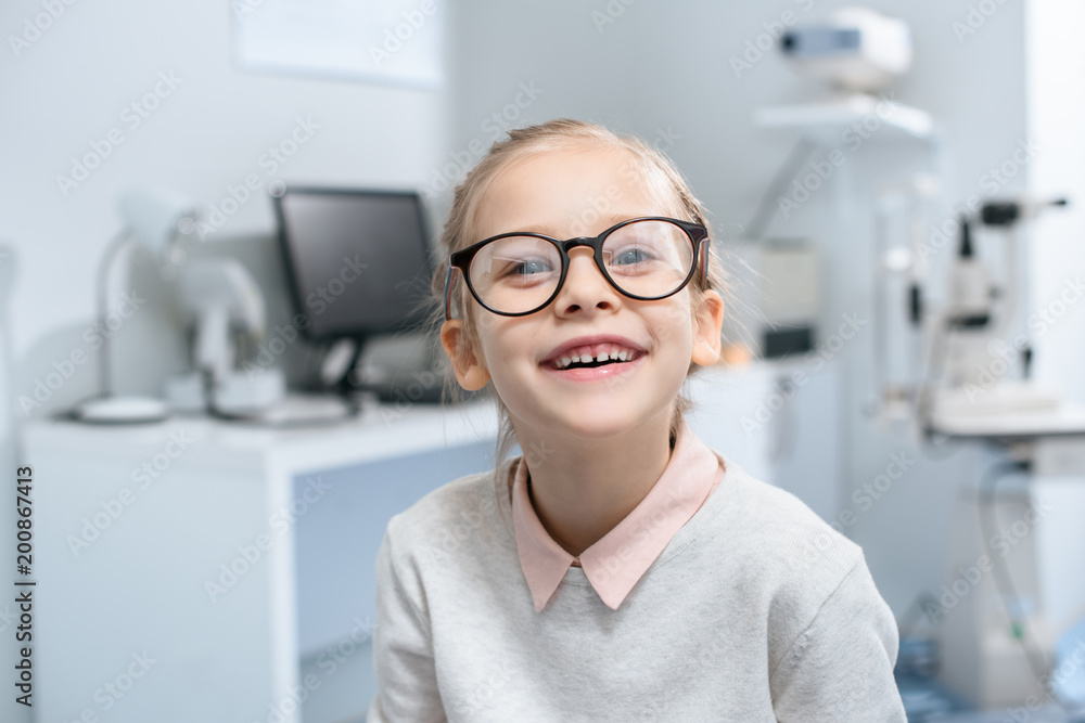 smiling little child in glasses in optical clinic smiling little child in glasses in optical clinic