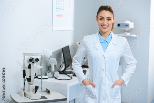 smiling female optometrist posing in optical clinic