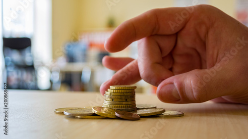 Photography A person uses his fingers to flick a coin stack.