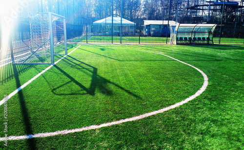 Soccer goal on green field with dramatic shadows background