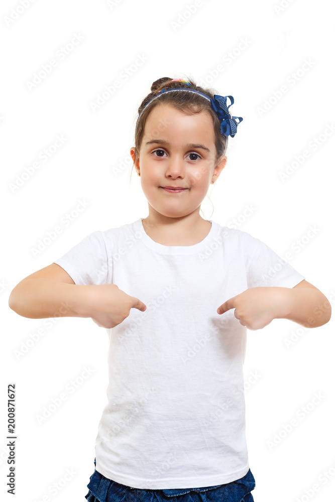 Positive little girl in casual white t shirt indicates at blank space for logo design Positive little girl in casual white t shirt indicates at blank space for logo design