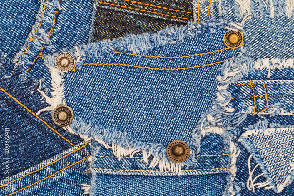 denim buttons on ripped denim patch and destroyed torn blue scraps. Denim  double seam jeans fashion background Stock Photo