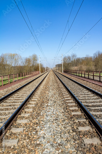 Spring landscape with railway under blue sky