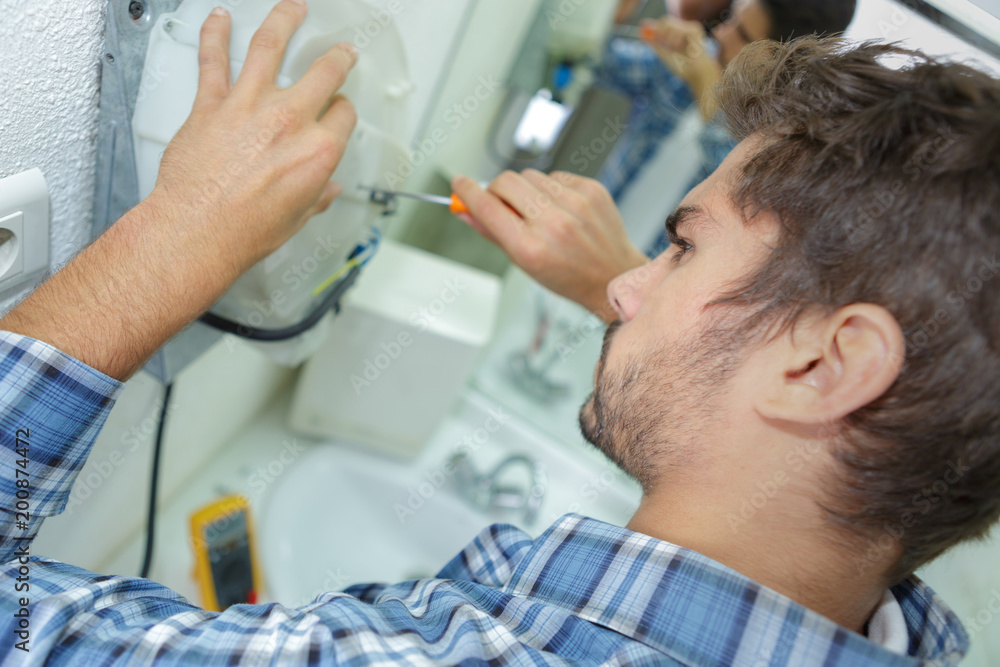 Fototapeta premium tradesman fixing electrical issue with hand dryer