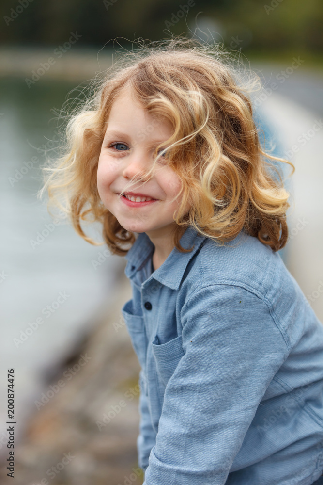 Happy child with long blond hair enjoying the holidays