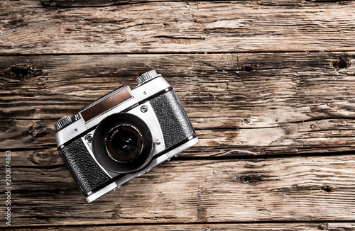 Retro camera on wooden table. Top view.