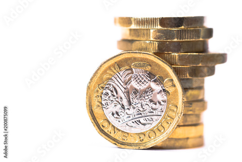 Stack of British Pound coins with one coin stood up at front