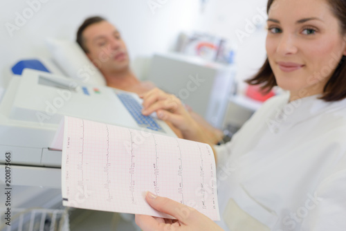 Εκτύπωση καμβά Woman looking at heart monitor printout