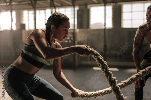 Tablou canvas Woman doing battle rope workout at gym