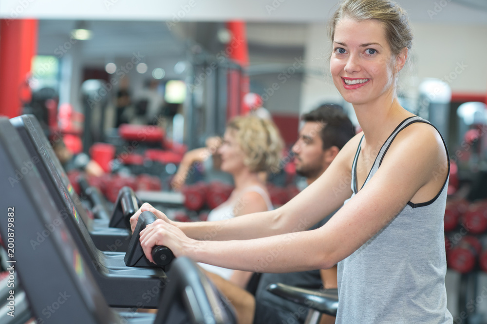 Obraz premium happy people doing indoor biking in a fitness club