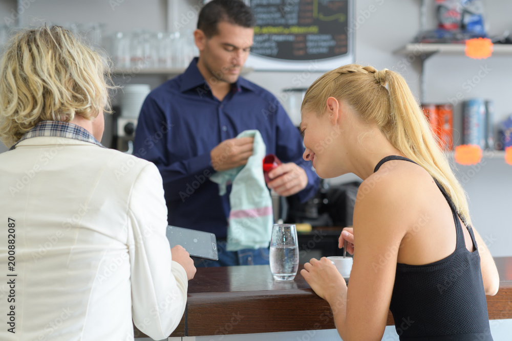 girl friends at the bar of a cafeteria girl friends at the bar of a cafeteria