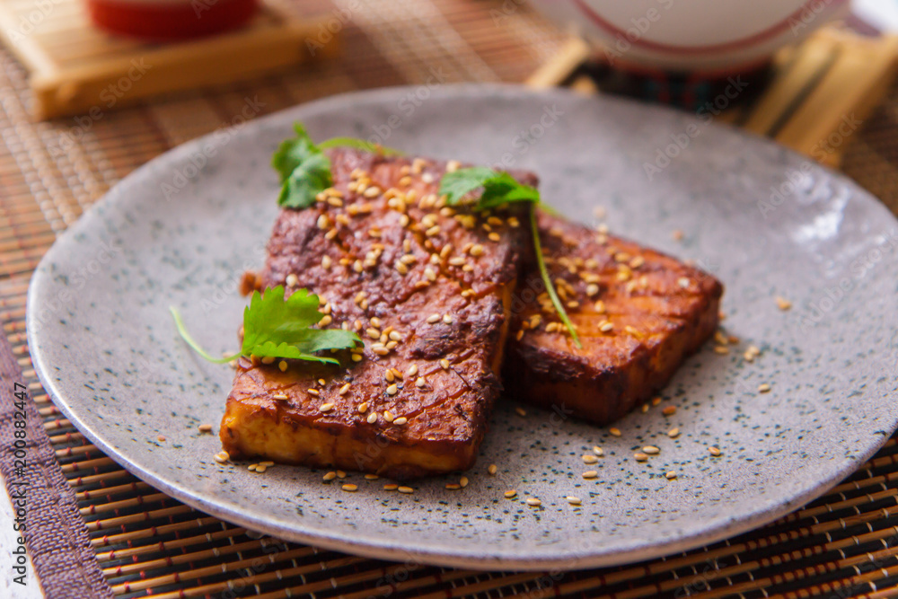 Fried tofu cheese with cilantro and sesame on a plate Fried tofu cheese with cilantro and sesame on a plate