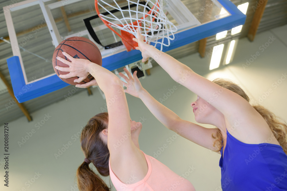 Naklejka premium Woman aiming for netball goal