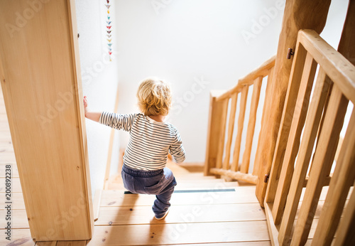 Toddler boy in dangerous situation at home. Child safety concept. photo