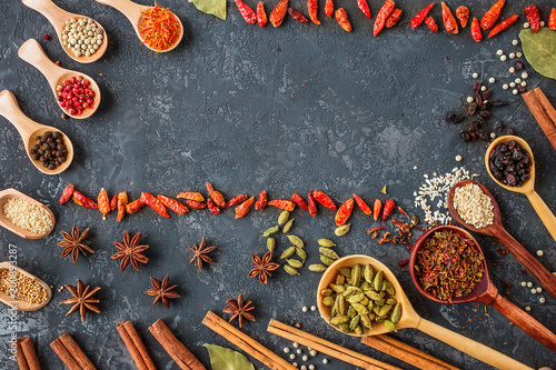 spices and herbs over black stone background