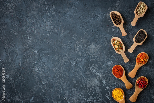 spices and herbs over black stone background. Flat lay