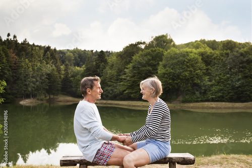 Senior couple sitting on a bench at the lake.