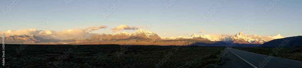 Rural road and the famed Fitz Roy mountain at dusk. Diminishing perspective. Panorama.