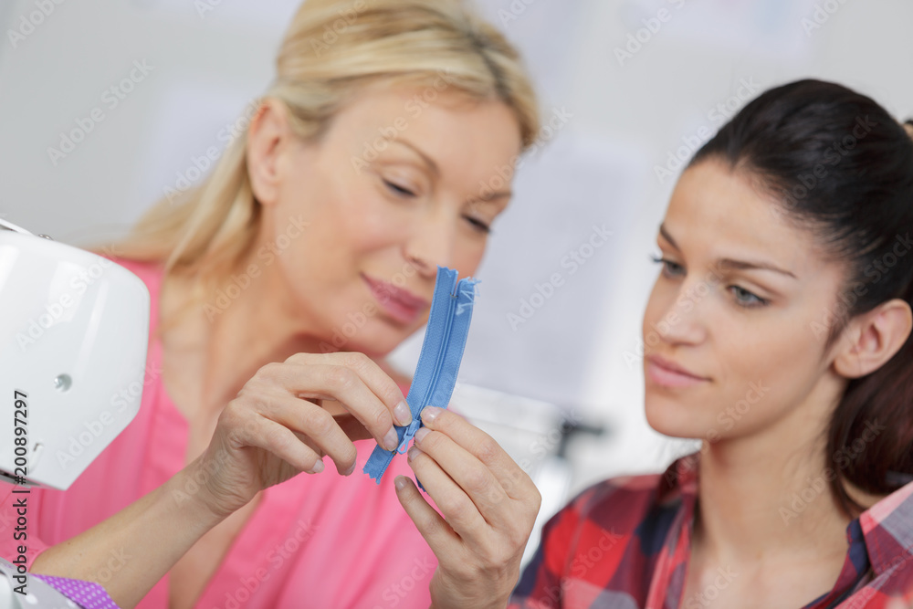 teacher helping college fashion student at class teacher helping college fashion student at class