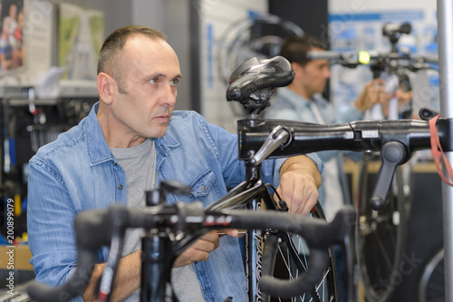 man checks a bike before buying in the sports shop