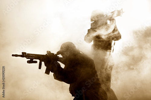 United States Marines in action. Military equipment, army helmet, warpaint, smoked dirty face, tactical gloves. Military action, desert battlefield, smoke grenades