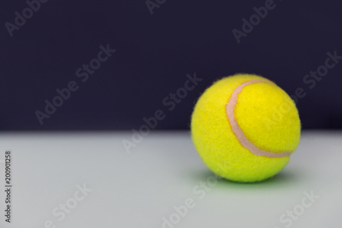Yellow tennis ball on dark background © Tom Eversley